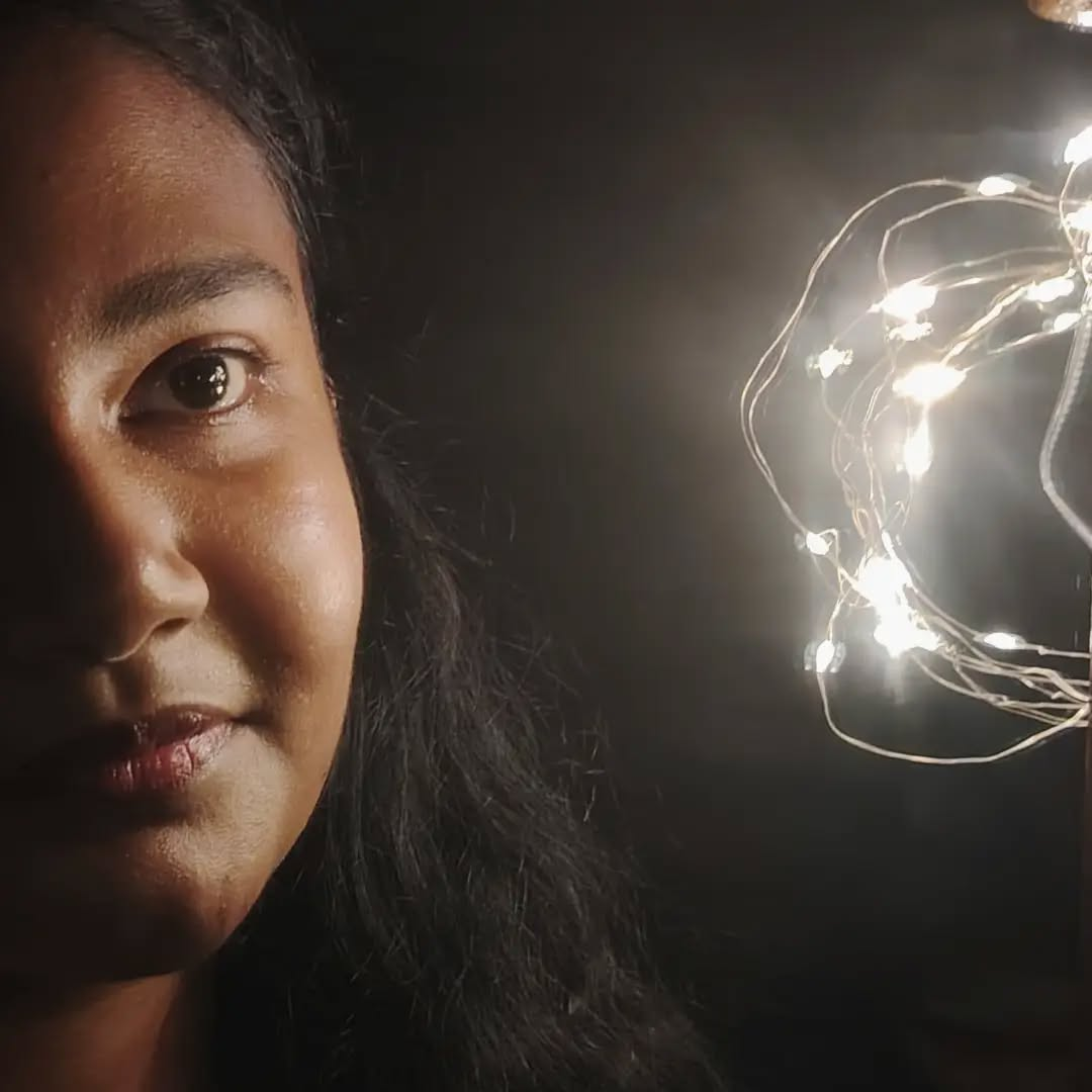 Maha smiling beside warm fairy lights