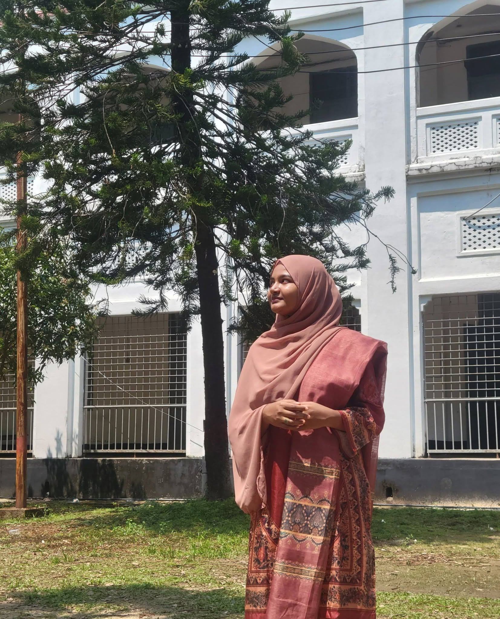 Maha standing outdoors beneath a tree